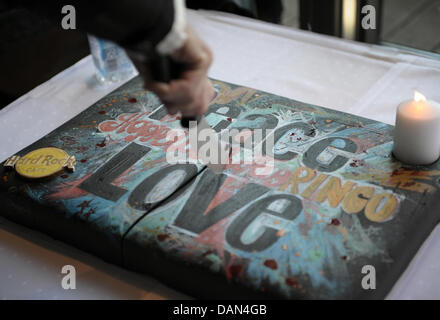 L'ancien Beatle Ringo Starr coupe son gâteau d'anniversaire à l'intérieur du nouveau Hard Rock Cafe à Hambourg, Allemagne, 07 juillet 2011. Le 07 juillet, Ringo Starr atteint 71 ans et lui et sa bande Starr tous ouvrir leur tournée en Allemagne. Photo : Christian Charisius Banque D'Images