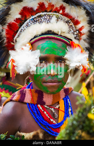 Portrait d'une jeune fille avec son visage peint en vert et portant une coiffe traditionnelle à l'Goroka show en Papouasie Nouvelle Guinée. Banque D'Images