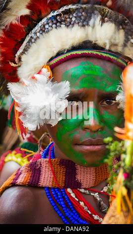 Portrait d'une jeune fille avec son visage peint en vert et portant une coiffe traditionnelle à l'Goroka show en Papouasie Nouvelle Guinée. Banque D'Images