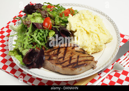 Ribeye Steak grillé, servi avec une purée de céleri-rave et pommes de terre salade de tomates, laitue à feuilles de chêne et de la fusée (roquette), Banque D'Images