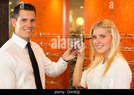 Opticien ou optométriste consulting un client sur les lunettes, les lunettes et les images d'un shop Banque D'Images