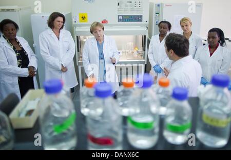 La chancelière allemande Angela Merkel (3e à g) et ministre allemand de protection des consommateurs et de l'Agriculture Ilse Aigner (2e à g) parler aux scientifiques au cours d'une visite à l'International Livestock Research Institute à Nairobi, Kenya, 12 juillet 2011. Merkel est titulaire d'entretiens politiques au Kenya et prononce un discours à l'Université de Nairobi. Dans la soirée, Mme Merkel va continuer ses voyages à un Banque D'Images