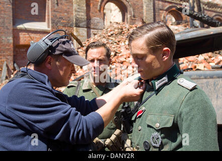 Acteurs Tom Schilling (R) et Volker Bruch (M) sont préparées par un concepteur de costumes pendant le tournage de la production de télévision allemande "Unsere Muetter, unsere Vaeter' ('nos mères, nos pères) à la région de l'ancienne usine de Hildebrand à Halle/Saale, Allemagne, 14 juillet 2011. Les trois parties du film par réalisateur Phillip Kadelbach raconte l'histoire de cinq amis durant la Seconde Guerre mondiale. Avant Banque D'Images