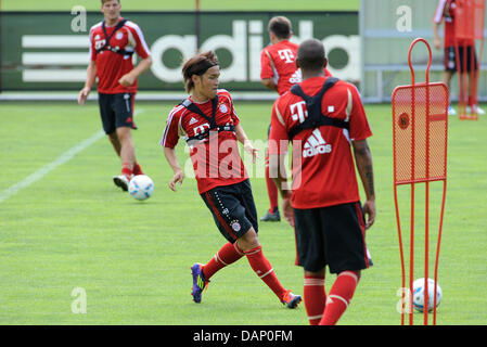 Nouveau joueur du FC Bayern Munich Takashi Usami (M) passe le ballon au cours de la pratique à la Bundesliga club équipements de diapos à Munich, Allemagne, 17 juillet 2011. Le 19-year-old Japanese player sera prêté cette saison. Photo : Andreas Gebert Banque D'Images