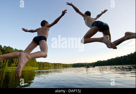 - Une archive de fichiers photo, datée du 05 juillet 2011, montre deux garçons sauter dans le lac près de Treplin Treplin, Allemagne. Jusqu'au 15 septembre 2011 des échantillons d'eau des lacs de baignade sont pris au moins une fois par mois pour les analyses microbiologiques pour assurer une bonne qualité de l'eau pour la baignade. Photo : Patrick Pleul Banque D'Images