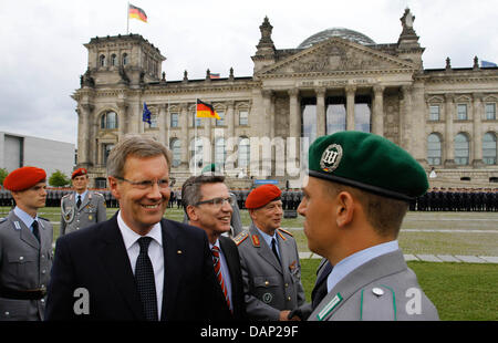 Le Président allemand Christian Wulff (L) et le ministre allemand de la Défense Thomas de Maizière nouvellement assermentés à féliciter les soldats pendant la prestation de serment de 470 nouvelles recrues de l'armée allemande, à l'occasion de l'anniversaire de l'échec de la tentative d'assassinat de 1944 Adolf Hitler à l'extérieur de l'édifice du parlement du Reichstag à Berlin, Allemagne, 20 juillet 2011. Les dirigeants de tracé le colonel Claus Schenk Graf von Stauffenberg Banque D'Images