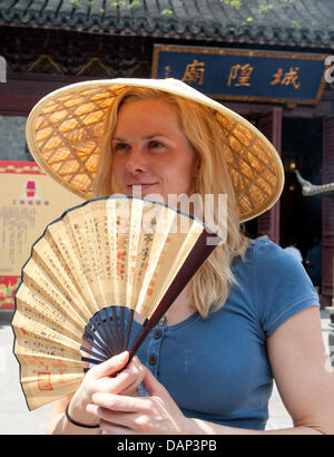 La nageuse allemande Britta Steffen est vu avec un chapeau chinois au cours d'une visite pour un rapport de l'ARD-Sportschau dans le jardin Yu avant les Championnats du Monde de Natation FINA 2011 à Shanghai, Chine, le 18 juillet 2011. Photo : Bernd Thissen dpa Banque D'Images