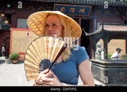 La nageuse allemande Britta Steffen est vu avec un chapeau chinois au cours d'une visite pour un rapport de l'ARD-Sportschau dans le jardin Yu avant les Championnats du Monde de Natation FINA 2011 à Shanghai, Chine, le 18 juillet 2011. Photo : Bernd Thissen dpa Banque D'Images