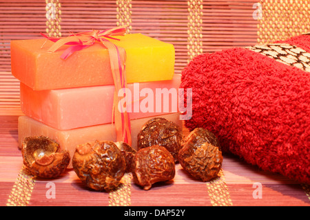 Savon artisanal, savon noix et serviette rouge sur le napperon de bambou. Produits Spa Banque D'Images