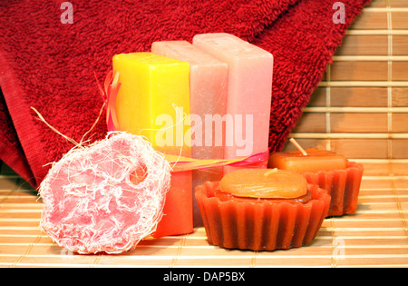 Savon artisanal au chocolat, des bougies et serviette rouge sur le bambou placemate closeup Banque D'Images