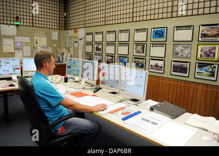 Un homme contrôle l'alimentation pour le démantèlement de l'ancienne salle de contrôle de la centrale nucléaire en Wuergassen Wuergassen, Allemagne, le 9 juin 2011. Les moniteurs sur le mur, qui ne sont plus requis, sont couverts par des photos. Le réacteur à eau bouillante s'est déroulé de 1975 à 1994. La centrale nucléaire a été arrêté le 14 avril 1997 et est en cours de démantèlement jusqu'en 2014. Photo : Uwe Banque D'Images