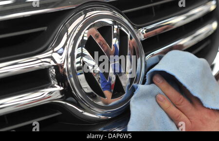 (Afp) - Un fichier photo datée du 24 février 2011 d'un employé avant le nettoyage de VW d'une voiture à la Volkswagen siège à Wolfsburg, Allemagne. Le 28 juillet 2011, constructeur automobile Volkswagen présentera son rapport de bilan semi-annuel. Photo : Jochen Luebke Banque D'Images