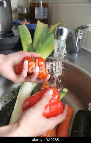 Fichier - ILLUSTRATION - une archive photo datée du 24 mai 2011 montre une femme, laver les légumes correctement dans un restaurant à Munich, Allemagne. Selon un sondage réalisé par l'institut de recherche YouGov pour le compte de l'agence de presse allemande, les Allemands payer plus d'attention à l'hygiène en cuisine et salle de bain même trois mois après l'infection à EHEC. Photo : Felix Hoerhager Banque D'Images