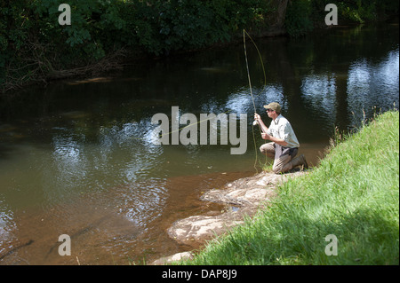 L'homme pêche de mouche sur la rivière dans le Devon, Angleterre Royaume-uni Lyd Banque D'Images