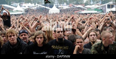 Heavy metal fans cheer pendant le premier concert dans le cadre de la metal festival à Wacken, Allemagne, 4 août 2011. Plus de 75 000 visiteurs sont attendus pour le Wacken Open Air, le plus grand festival de heavy metal. Photo : Carsten Rehder Banque D'Images