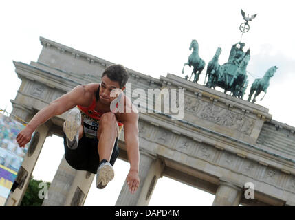 L'Allemagne Sebastian cavalier Bayer passe devant la porte de Brandebourg à Berlin, Allemagne, 12 août 2011. Pour la première fois, l'athlétisme monde et champions d'Europe de l'USA, la France, l'Allemagne et la Russie participent à l'équipe de Défi 'Berlin Berlin fliegt !' (oiseau) en face de la porte de Brandebourg. À l'équipe de conception nouvelle de la compétition sportive allemande Banque D'Images