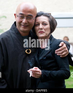 Poète et écrivain chinois Liao Yiwu (L) et l'allemand d'origine roumaine, lauréate du prix Nobel de littérature Herta Müller s'embrassent lors d'une séance de lecture à Berlin, Allemagne, 17 août 2011. Liao Yiwu a présenté son dernier livre "mon témoignage" en Allemagne. Photo : Joerg Carstensen Banque D'Images