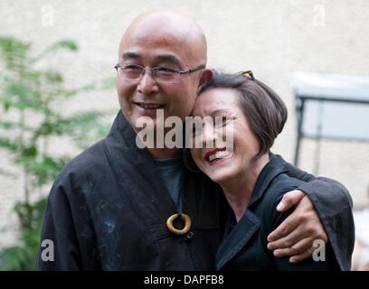 Auteur et poète chinois Liao Yiwu (L) et l'allemand d'origine roumaine, lauréate du prix Nobel de littérature Herta Müller s'embrassent lors d'une séance de lecture à Berlin, Allemagne, 17 août 2011. Liao Yiwu a présenté son dernier livre "mon témoignage" en Allemagne. Photo : Joerg Carstensen Banque D'Images