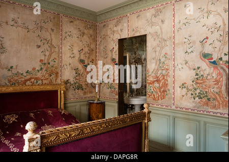 Papier de riz chinois peint des panneaux de mur dans la chambre à coucher avec lit doré du 18ème siècle et couvre-lit en velours brodé de fil d'or. Banque D'Images