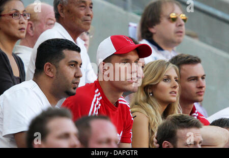 Cologne, Lukas Podolski blessé porte un bonnet rouge comme il regarde le match sur le stand des spectateurs lors de la Bundesliga match de foot entre 1er FC Cologne et 1er FC Kaiserslautern au stade RheinEnergieStadion à Cologne, Allemagne, 20 août 2011. Photo : Rolf Vennenbernd Banque D'Images