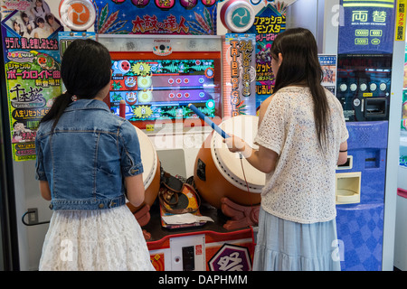 Les Jeunes filles jouant du tambour Taiko no Tatsujin Jeu rythmique, Kagoshima, Japon Banque D'Images
