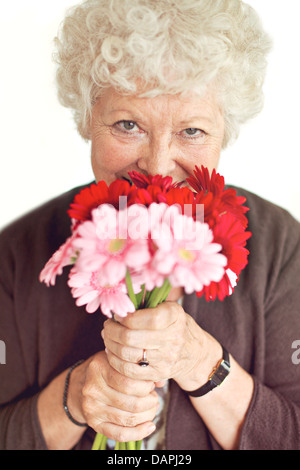 Grand-mère joyeuse heureuse d'avoir reçu des fleurs le jour de la mère Banque D'Images