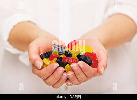Femme avec une poignée de bonbons multicolores Banque D'Images
