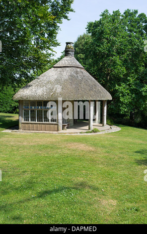 Dartington, Devon, Angleterre. Le 15 juillet 2013. Une maison d'été de chaume dans les motifs de Dartington Hall. Banque D'Images