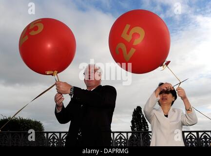 Le Premier Ministre du Schleswig-Holstein Peter Harry Carstensen (L) et Ming Feng, vice-présidente du Congrès du peuple du Zhejiang (R) envoyer ballons avec le numéro 25 dans l'air à Ploen Palace à Ploen, Allemagne, 29 août 2011. Ils célèbrent le 25e anniversaire du jumelage entre l'Etat du Schleswig-Holstein et de Zhejiang. Photo : Carsten Rehder Banque D'Images