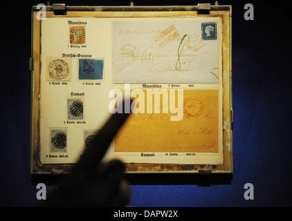 Un doigt pointe vers la soi-disant 'Mauritius-Tableau" à l'exposition du Musée de la communication "Le Blue Penny' à Berlin, Allemagne, 01 septembre 2011. La 'Mauritius-Tableau" inclut un Maurice rouge un sou sceau postal à partir de 1847 et d'un blue Maurice deux pence Poster Offfice stamp à partir de 1847. L'exposition, qui présente 18 des 27 existant encore, s'étend de 2 timbres Banque D'Images