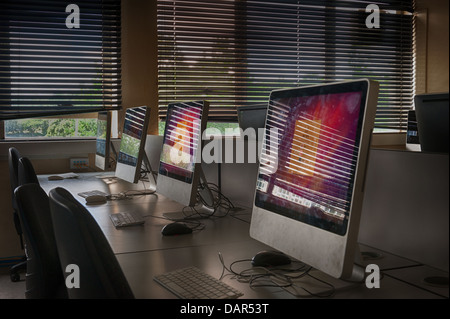 La fin de l'école ou du collège, tel que nous le connaissons, lignes d'ordinateurs dans une salle de classe sombre beaucoup auparavant utilisée maintenant en attente d'être utilisé Banque D'Images