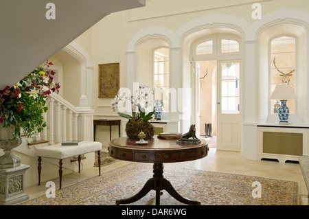 Table ronde antique dans hall d'entrée de l'anglais country house Ampney Park, manoir anglais du 17ème siècle Banque D'Images