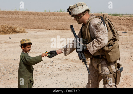 Un Marine américain donne un jeune garçon candy pendant une opération de bouclage et de recherche mission le 27 juin 2013 dans Habib Abad, dans la province d'Helmand, en Afghanistan. Banque D'Images