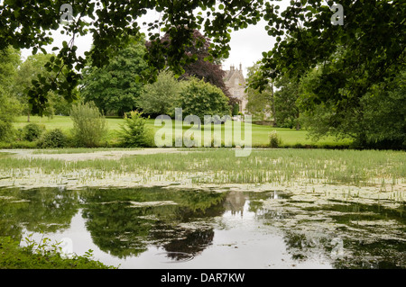 Dans les jardins de l'étang d'Ampney Park, maison de campagne Anglaise du 17e siècle Banque D'Images