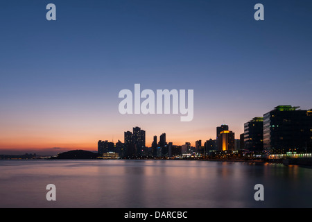 Une vue de la nuit de l'horizon de la plage de Haeundae à Busan, Corée du Sud vu de Mipo ferry terminal. Une longue exposition photographie au coucher du soleil. Banque D'Images