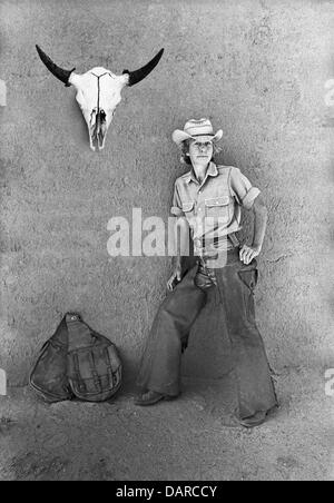 Une cowgirl, vivant dans un petit ranch dans le bassin du nord de Galisteo au Mexique, vers 1974, avec un crâne de vache et sacoches Banque D'Images