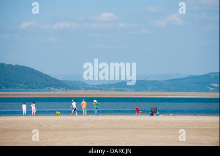 L'estuaire de Dovey/Borth, Ceredigion, pays de Galles, Royaume-Uni. 17 juillet 2013. Une famille jouissent de la liberté et de l'espace. Une étendue de sable plat dur - qui offre un immense parking pour les voitures à 1 € par voiture par jour - dans la Dovey Dyfi (en gallois) Estuaire, fait partie d'une grande surface des eaux côtières soutenue par la campagne du Pays de Galles et du Conseil ainsi que les dunes de sable environnantes offre un magnifique salon pour les gens d'échapper à la vague de chaleur qui a été la Grande-Bretagne torride pendant près de deux semaines. L'accueil cool brise de mer soufflent en provenance de la mer d'Irlande. Crédit photo : Graham M. Lawrence/Alamy Live News. Banque D'Images