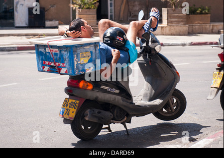 Israël Jaffa Yafo livraison de pizza boy équilibrée homme couché dans soleil sur Classic Duc 125 cyclomoteur moto scooter cycle vélo Banque D'Images