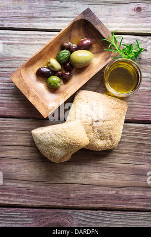 Assorted olives marinées avec du pain et d'huile d'olive sur une table en bois rustique Banque D'Images