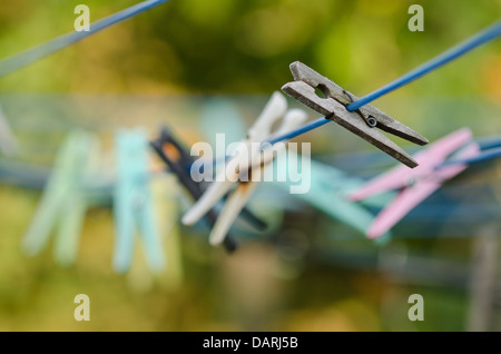 Rangée de vieux nouveau plastique en bois des pinces à linge sur un fil a linge du flou historique prêt pour laver un travail quotidien Banque D'Images