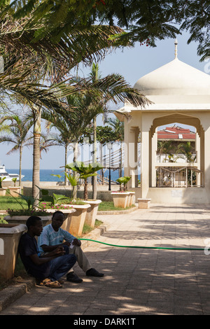 L'Afrique, Tanzanie, Zanzibar, Stone Town. Les hommes assis à l'ombre près de Forodhani Gardens gazebo. Banque D'Images