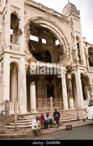 L'Afrique, l'Érythrée, Massawa, Vieille Ville, les hommes assis dehors Banco d'Italia, l'ancienne banque, bataille structure endommagée Banque D'Images