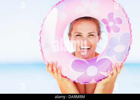 Jeune femme sur la plage à la nage par joint torique Banque D'Images