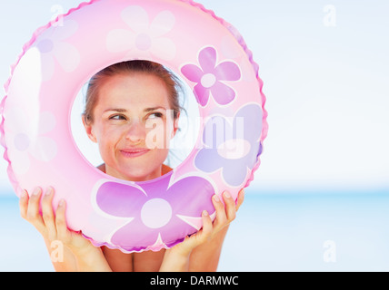 Young woman on beach à nager par joint torique sur copy space Banque D'Images