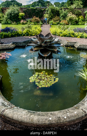 Style floral orné d'une fontaine dans un grand jardin formel. Banque D'Images