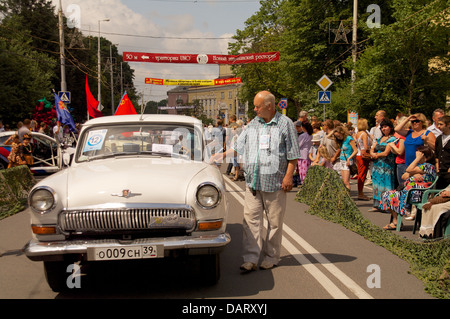 Homme avec ancienne rétro 'Volga GAZ 21' sur la rue Banque D'Images