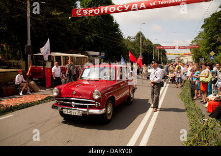 L'homme avec l'ancienne voiture rétro soviétique "oskvich' sur la rue Banque D'Images