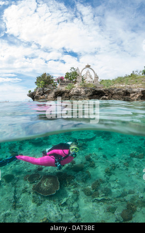 Duplex vue du plongeur sous-marin explorant blonde aux côtés d'île tropicale, temple hindou de l'arrière-plan Banque D'Images