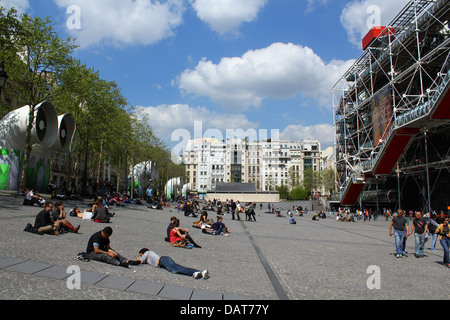 Les touristes assis relaxant / pose en face du Musée d'Art Moderne (Centre Georges Pompidou) à Paris, France Banque D'Images