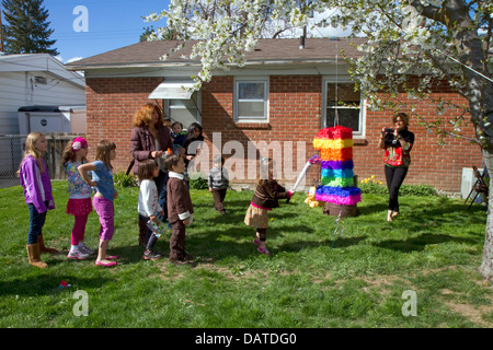 Les enfants frapper une piñata, lors d'une fête d'anniversaire de childs hispanique à Boise, Idaho, USA. Banque D'Images